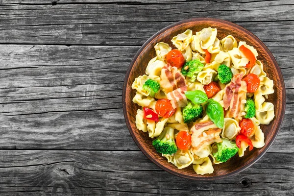 Tortellini with grilled cherry tomatoes, broccoli, red bell pepper, top view — Stock Photo, Image