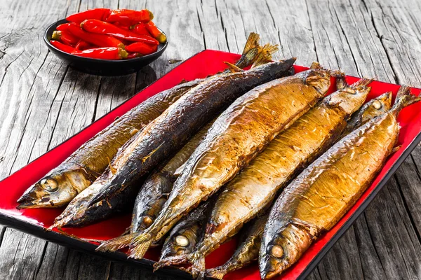 Baked saury on a red rectangular dish , close-up top view — Stock Image Baked saury on a red rectangular dish , close-up top view Stock Photo