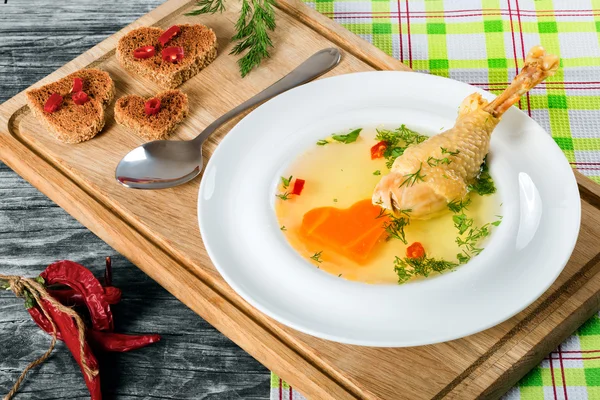 Soup with carrot and chicken leg decorated with dill — Stock Image Soup with carrot and chicken leg decorated with dill Stock Image