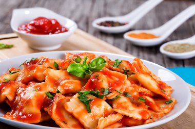  ravioli with tomato sauce and basil leaves clipart