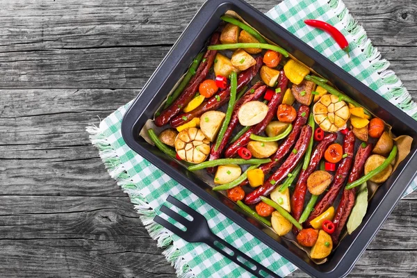 Grilled sausage with garlic, potato, cherry tomatoes, green beans, top-view — Stock Photo, Image