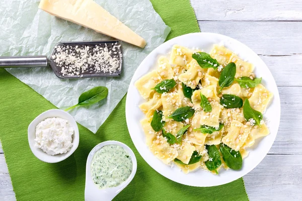 Italian ravioli with creamy spinach sauce, top view — Stock Photo, Image