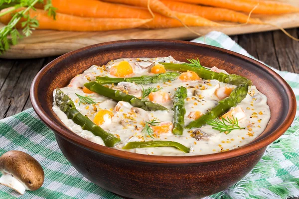 Cheese mushroom soup with spring carrots and asparagus spears — Stock Image Cheese mushroom soup with spring carrots and asparagus spears Stock Photo
