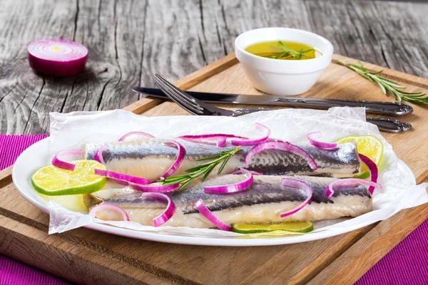 Filetes de arenque con cebolla y rodaja de lima, primer plano —  Fotos de Stock