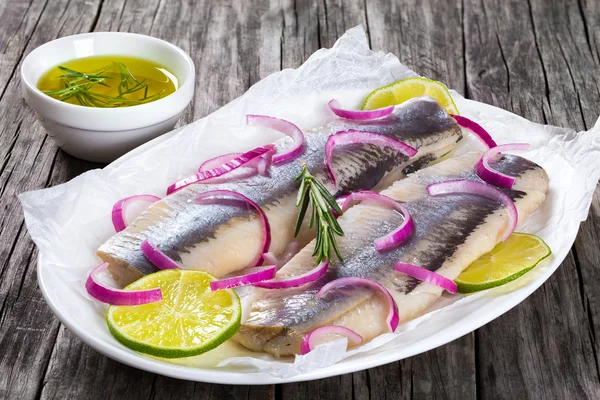 Filetes de arenque con cebolla y rodaja de lima, primer plano — Foto de Stock