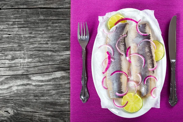 Filets de hareng avec oignon et tranches de lime, vue de dessus — Photo