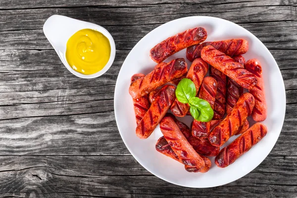 Grilled sausages on a white dish, top view — Stock Photo, Image