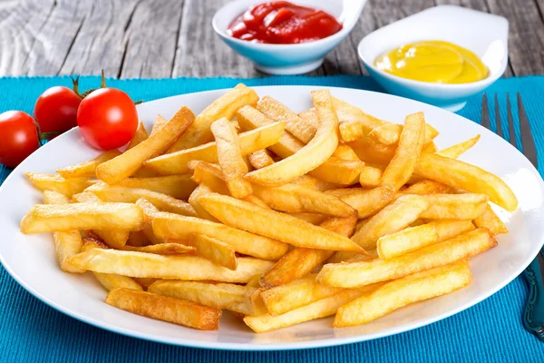 Leckere Pommes auf Teller, auf Holztischhintergrund — Stockfoto