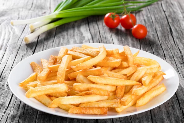 Leckere Pommes auf Teller, auf Holztischhintergrund — Stockfoto