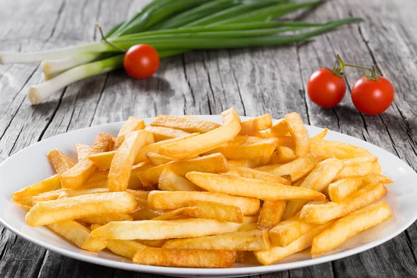 Leckere Pommes auf Teller, auf Holztischhintergrund — Stockfoto