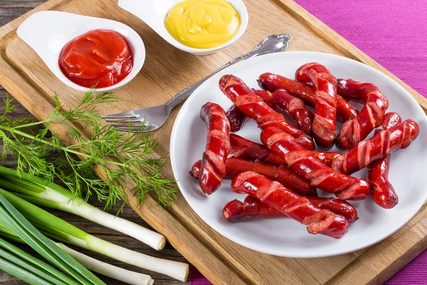 Gegrilde worstjes op een witte schotel, bovenaanzicht — Stockfoto