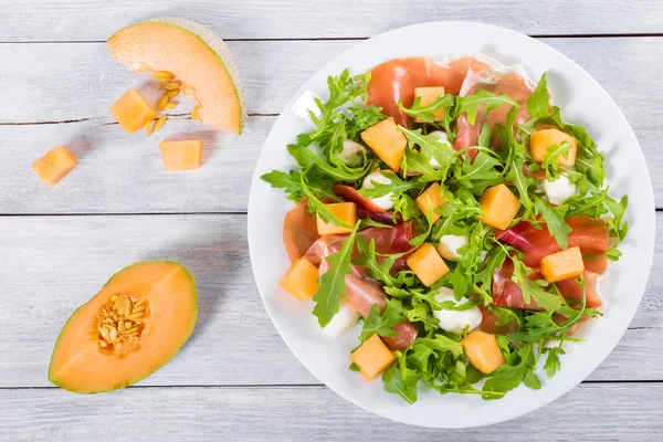 Arugula, prosciutto, mozzarella și salată de pepene galben, vedere de sus — Fotografie, imagine de stoc