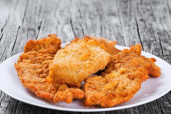 bread crumb chicken chop on white dish. closeup