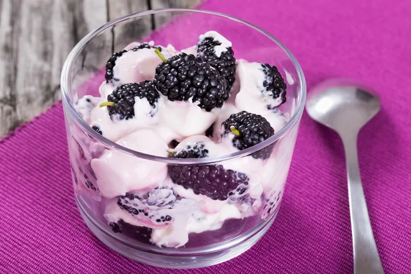 Verse Griekse yoghurt met bessen op glazen beker — Stockfoto