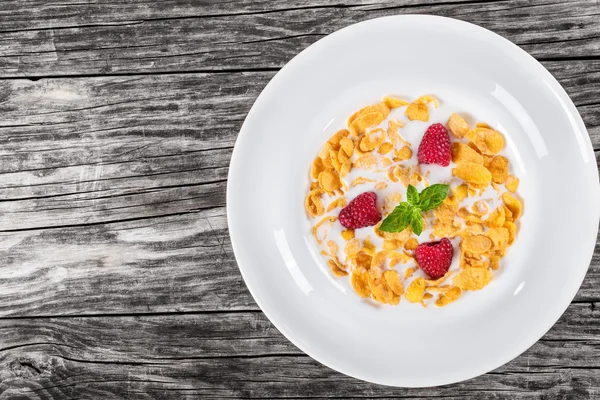 Corn flakes with raspberry and cold milk, top view — Stock Photo, Image