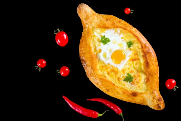 Khachapuri isolado em fundo preto com tomate cereja e — Fotografia de Stock