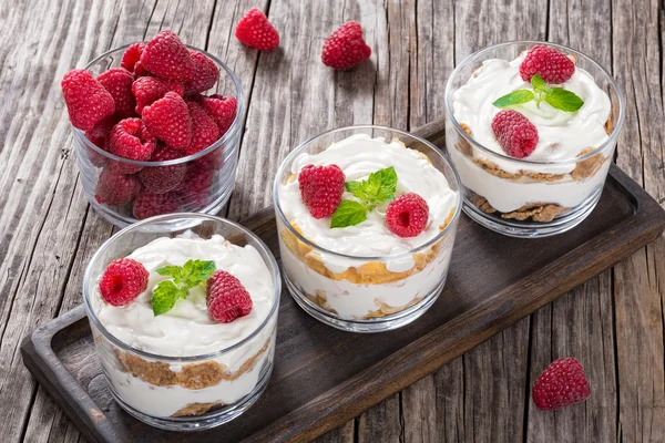 Joghurt in Tassen mit Vollkornflocken und Himbeere — Stockfoto