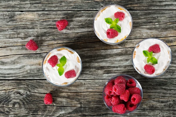 Йогурт в чашках с малиной, цельными зерновыми и кукурузной мукой — стоковое фото