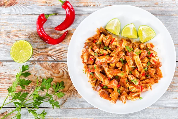 Gestoofde varkens oren met specerijen, chili peper, stukjes limoen — Stockfoto