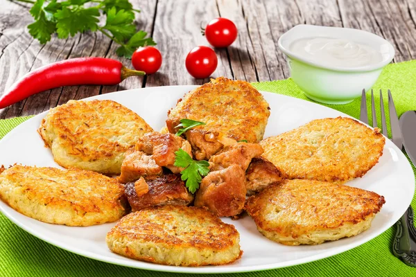 Aardappelen pannenkoeken met gestoofde varkensvlees. Close-up — Stockfoto