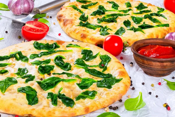 Handgeschleuderte Spinat-Käse-Pizza auf Pergamentpapier — Stockfoto