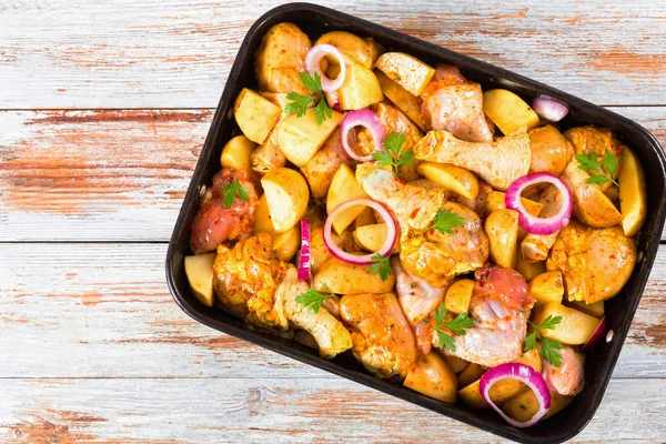 Potatoes wedges, red onion,chicken wings and drumstick — Stock Photo, Image