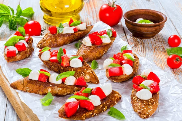 Bruschetta con tomates, mozzarella y albahaca, primer plano —  Fotos de Stock