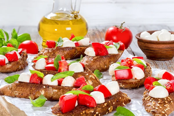 Bruschetta with tomatoes, mozzarella and basil,  ingredients on — Stock Photo, Image