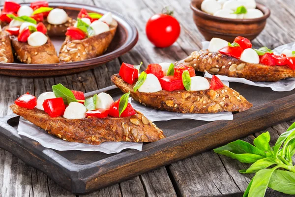 Bruschetta con tomate, mozzarella y albahaca, primer plano —  Fotos de Stock