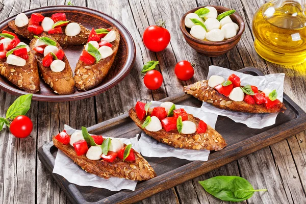 Bruschetta with tomatoes, mozzarella and basil, close-up — Stock Photo, Image