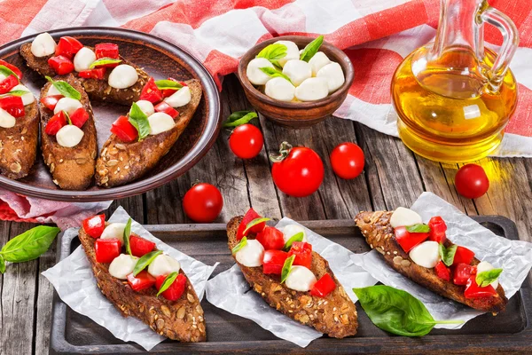 Bruschetta con tomate, mozarella y albahaca, primer plano —  Fotos de Stock