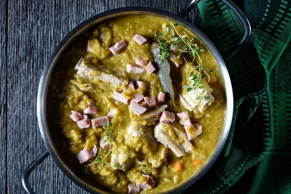 Green peas finnish soup with pork ribs and ham in a pot, horizontal view from above, flat lay, close-up — Stock Image Green Peas Finnish Soup Pork Ribs Ham Pot Horizontal View Royalty Free Stock Photos