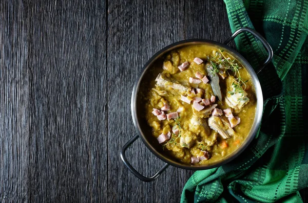 Green peas finnish soup with pork ribs and ham in a pot, horizontal view from above, flat lay, free space — Stock Image Green Peas Finnish Soup Pork Ribs Ham Pot Horizontal View Royalty Free Stock Images