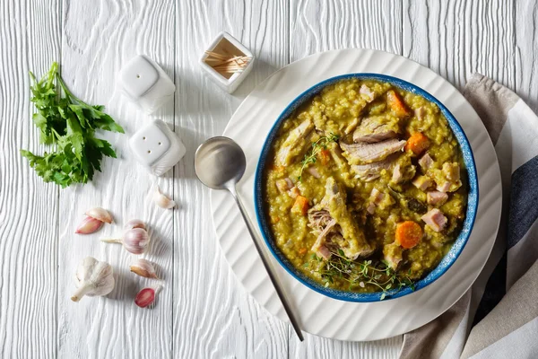 Green peas finnish soup with pork ribs and ham in a bowl, horizontal view from above, flat lay — Stock Image Green Peas Finnish Soup Pork Ribs Ham Bowl Horizontal View Stock Photo