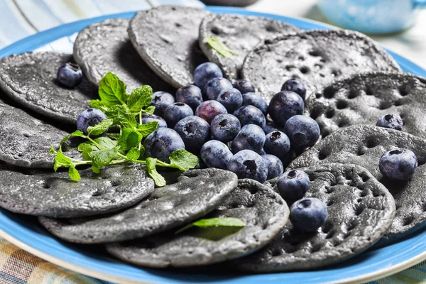 Black Sweet Pancakes Served Blueberries Mint Blue Plate White Wooden — Stock Photo, Image