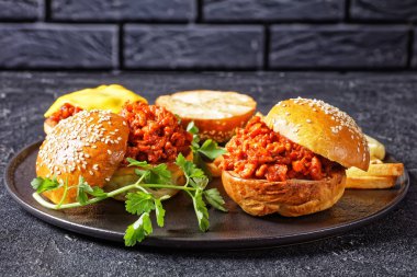BBQ Sloppy Joe sandwiches with french Fries on a black plate with a brick wall at the background, close-up, american cuisine clipart