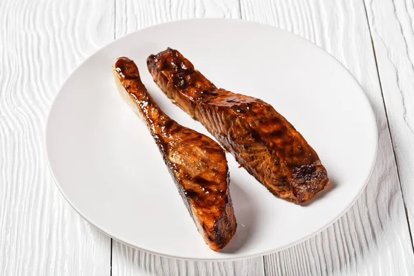食感のある木のテーブルの上に盛り付けられた白身魚の照り焼き — ストック写真