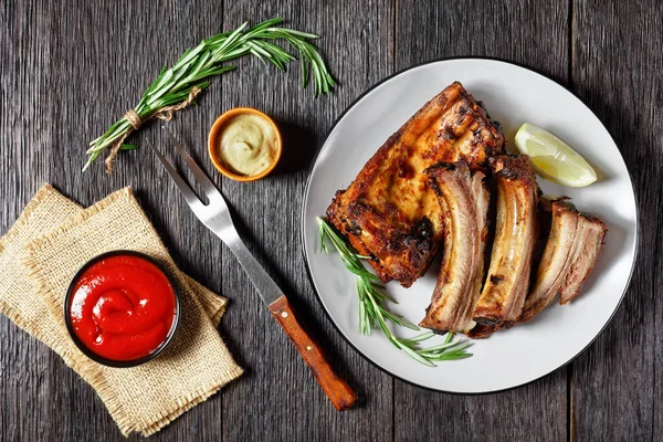 Grillade Fläskrevben Med Citron Och Rosmarin Tallrik Ett Mörkt Träbord — Stockfoto