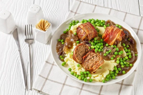 イギリスのミートボールとクリーミーなマッシュポテト 緑のエンドウ豆と豊かな 厚いタマネギのグレービーホワイトプレート 古典的な英国料理 — ストック写真