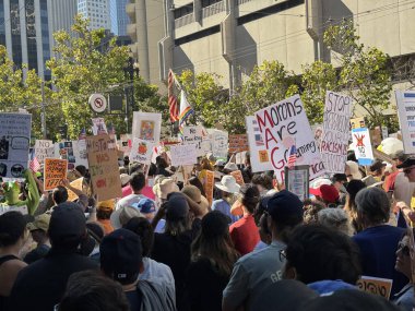San Francisco, California USA; 10.18.2025: Annemler de dahil olmak üzere çeşitli tabelalar taşıyan göstericilerle dolu canlı bir sokak, NoKings protesto hareketine geniş katılımını gösteriyor.