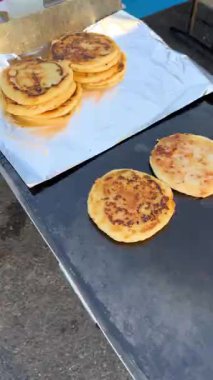 İki tam tamına ızgarada pişmiş pupa, folyodaki, altın kahverengideki ve kaplamaya ya da paketlemeye hazır bir yığın başka balığın yanında oturur..