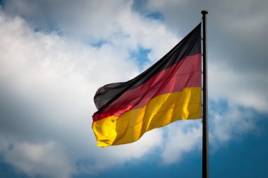 Alman bayrağı mavi gökyüzü Rüzgar içinde çırpınan bir arka planda beyaz bulutlar ile