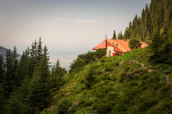 Edifício antigo albergue com telhado vermelho nas montanhas da Roménia — Fotografia de Stock