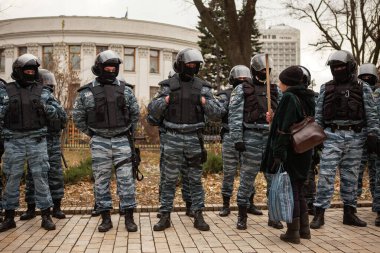 KYIV, UKRAINE DEC 1, 2011 Yaşlı kadın Ukraynalı Verkhovna Rada (Parlamento) yakınlarında Çernobil kurbanlarının gösterisi sırasında Berkut çevik kuvvet polisini sopayla tehdit etti