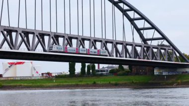 Stadtbahn Tren Köprüsü Köln Almanya 'da Ren Nehri üzerindeki Deutzer Köprüsü' nde Kargo Mavnası Grafiti Duvarları ve Şehir Manzarası Altında Bulutlu Gün