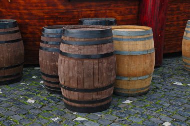 Birkaç ahşap varil bir kaldırım taşı yolunun yanında düzenlenir, kırsal bir açık hava manzarası sergilenir..