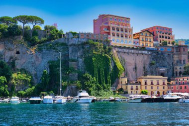 Renkli Binalar ve Turkuaz Sulara Bakan Lüks Vittoria Oteli ile canlı Cliffside Marina Açık Mavi Gök Altında Amalfi Sahili Altında Yat ve Teknelerle Dolu