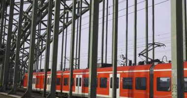 Köln 'deki Ren Nehri üzerindeki Hohenzollern Köprüsü' nü geçen Kızıl Deutsche Bahn Treni