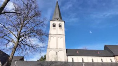 Yavaşça yukarı doğru hareket eden kamera Almanya 'da dramatik mavi gökyüzüne karşı kilise kulesini gösteriyor.