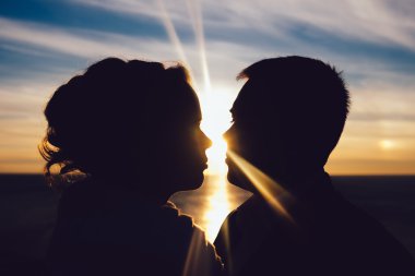 sevgi dolu bir çift günbatımında öpüşme siluet
